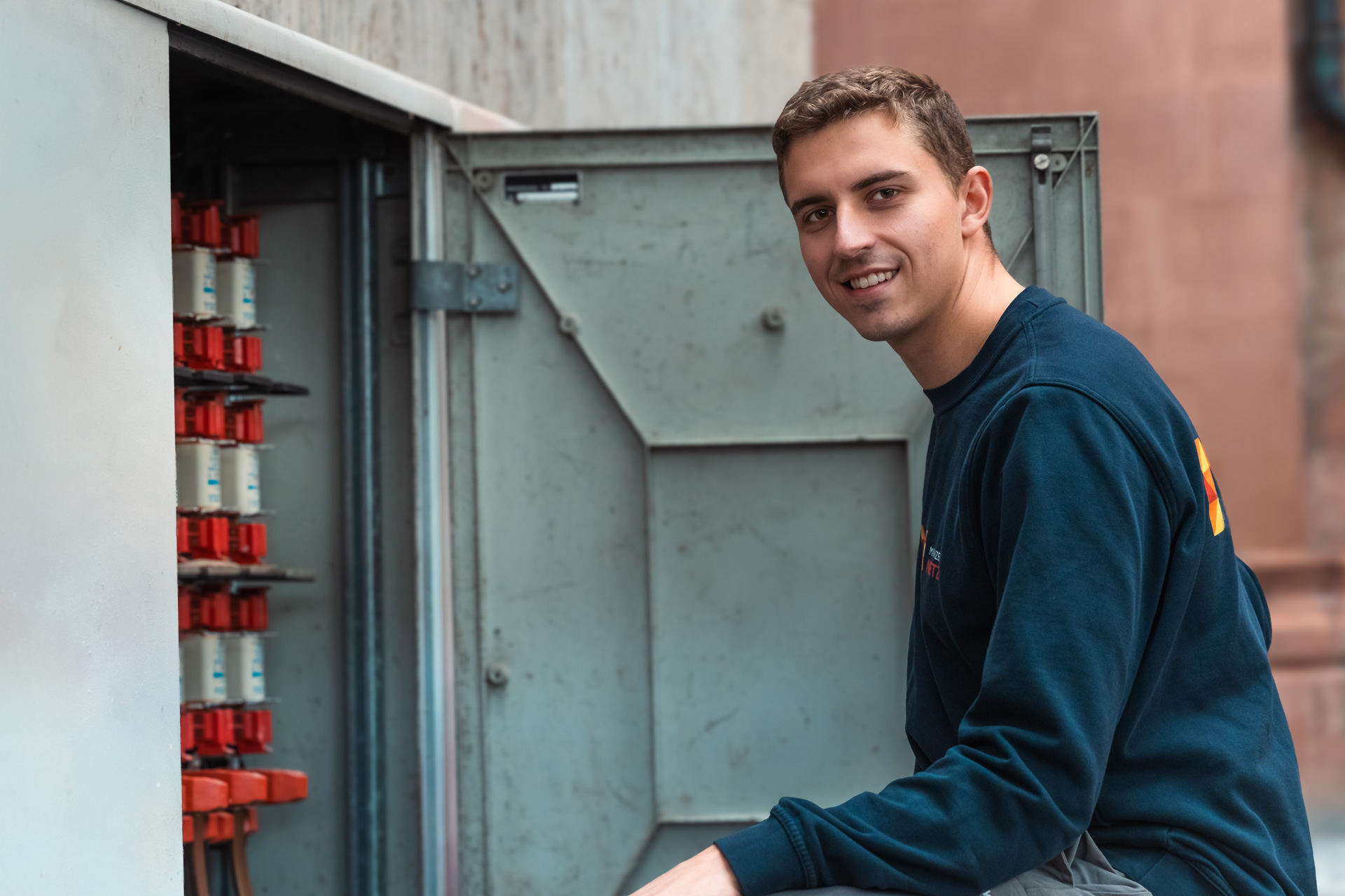 Kollege steht vor dem Verteilerkasten